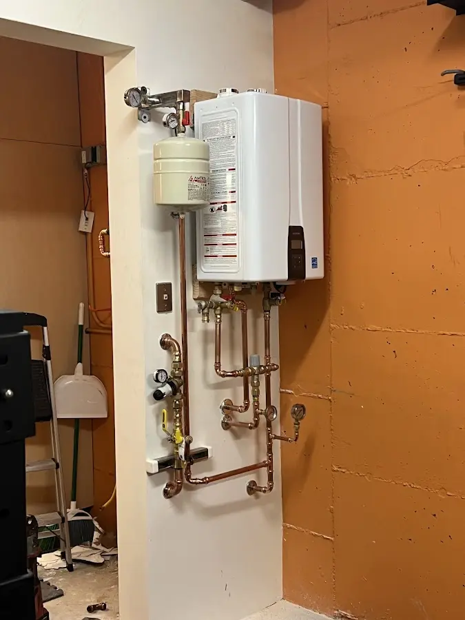Plumbing technician inspecting water heater connections in Maumelle